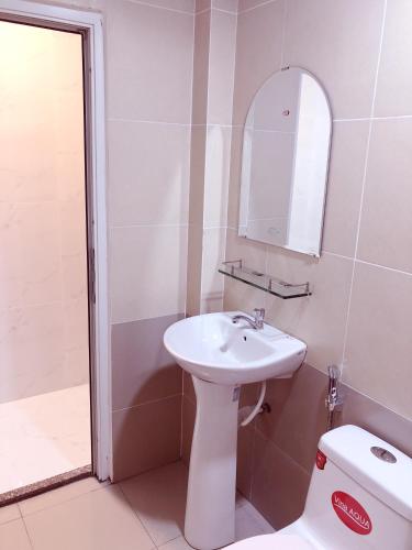 a bathroom with a sink and a mirror and a toilet at Aurora Hotel in Ho Chi Minh City
