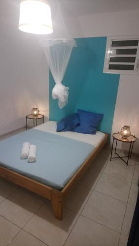 uma cama num quarto com uma parede azul em La Kay'Loulou avec spa et piscine em Saint-Pierre