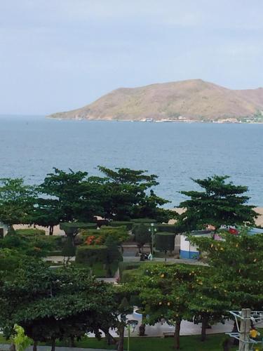 a group of trees in front of a body of water at Khánh An Hotel in Nha Trang