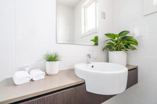 a white bathroom with a sink and a mirror at Huskisson Hotel in Huskisson