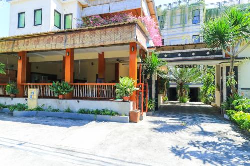 a building with palm trees in front of it at Rantun's Place Nusa Dua in Nusa Dua