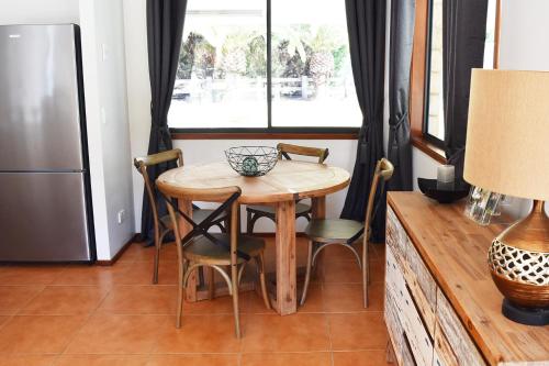 a kitchen with a table and chairs and a refrigerator at Canungra Valley Cottage in Canungra