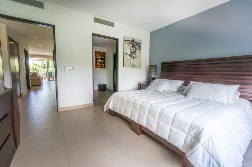 1 dormitorio con 1 cama grande y cabecero de madera en Vaiven Condo by BVR, en Playa del Carmen