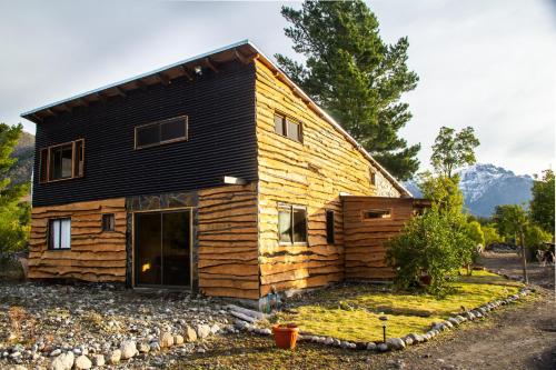 a log cabin with a black roof at Rincon del Montañes in Antuco