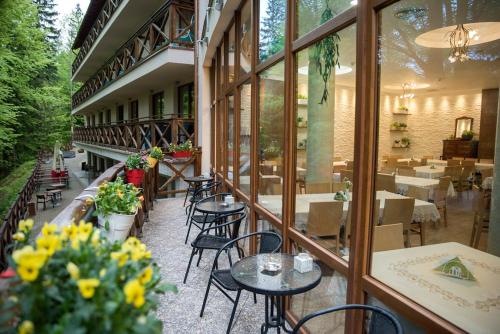 balkon restauracji ze stołami i krzesłami w obiekcie Hotel EUROPA - Górnicza Strzecha w Szklarskiej Porębie