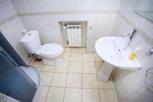 a white bathroom with a toilet and a sink at 12 Місяців-Травень, басейн з підігрівом in Slavske