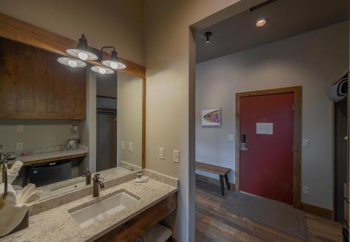 uma casa de banho com um lavatório e um espelho grande em Golden Stone Inn em West Yellowstone
