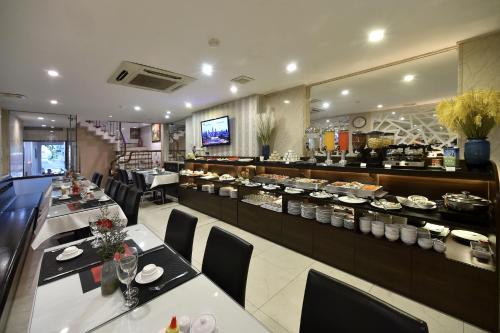 a restaurant with tables and chairs and a buffet at Hanoi Eternity Hotel in Hanoi