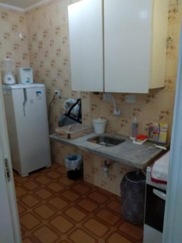 uma cozinha com um lavatório e um frigorífico em Flat Praia Pitangueiras no Guarujá