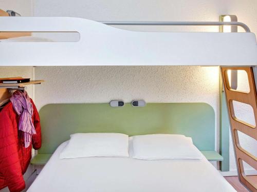 a bunk bed with two white pillows in a room at Hotel Ibis Budget Vichy in Bellerive-sur-Allier