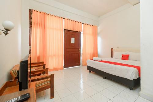 a bedroom with a bed and a flat screen tv at RedDoorz @ Tuktuk Danau Toba in Tuk Tuk