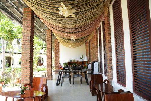 a room with tables and chairs and a ceiling at Binh Minh Eco Lodge in Can Tho