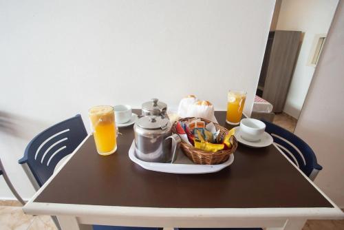 einen Tisch mit einem Tablett mit Essen und zwei Gläsern Orangensaft in der Unterkunft Hotel Golden Vilage Vila Maria in São Paulo