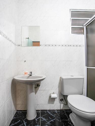 a white bathroom with a sink and a toilet at Hotel Golden Vilage Vila Maria in São Paulo