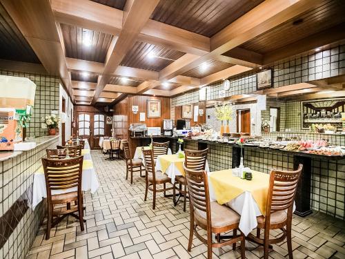 ein Restaurant mit Tischen und Stühlen und einer Theke in der Unterkunft San Francisco Plazza Hotel in São Paulo