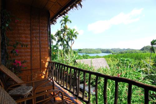a balcony of a house with a view of a river at Palau Plantation Resort in Koror