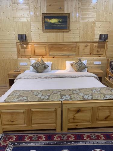a large bed in a room with wooden walls at Adu's Eternal Comfort in Leh
