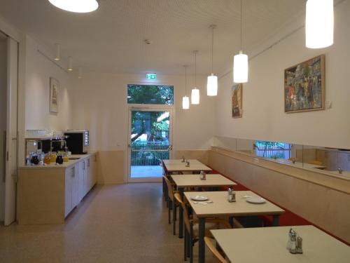 a restaurant with tables and chairs and a counter at Haus Mobene - Hotel Garni in Graz