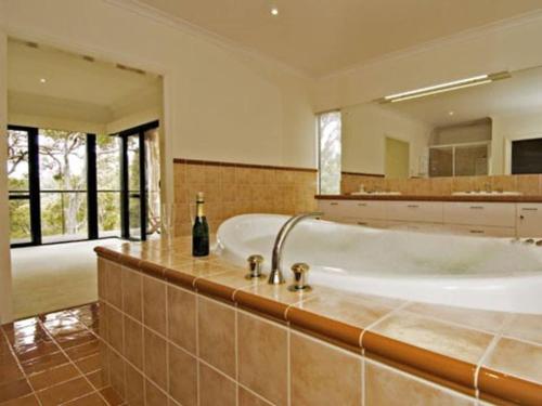 a large bathroom with a tub and a large mirror at ARUM in Margaret River Town