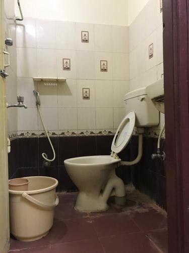 a bathroom with a toilet and a sink at Greens Residency in Bengaluru