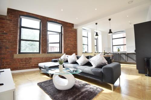a living room with a couch and a table at Aire Apartments New York Styled Luxury Apartments in Leeds
