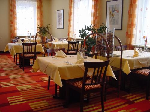 a dining room with tables and chairs with yellow table cloth at Hotel Teinachtal in Bad Teinach-Zavelstein
