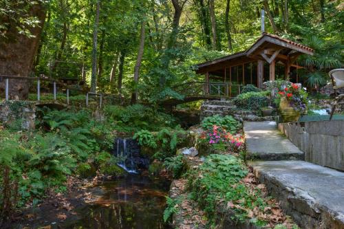a garden with a pond and a cabin at Hotel Saint Nedelya in Kolarovo
