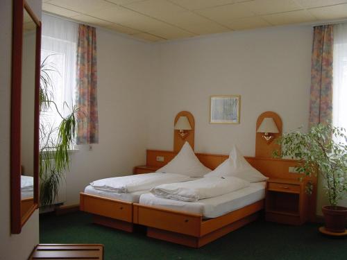 a bedroom with two beds and a window at Hotel Teinachtal in Bad Teinach-Zavelstein