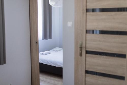 a door leading to a bedroom with a bed at Apartament z dużym balkonem Osiedle Zwycięzców in Polanica-Zdrój