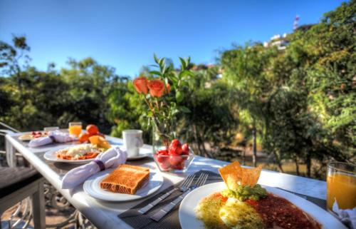 巴亞爾塔港的住宿－里維拉德爾里奧精品酒店，桌子上放着盘子的桌子