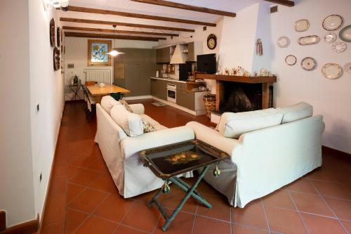 a living room with two white couches and a fireplace at Il Rifugio in Pracchia