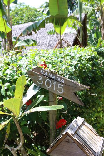 a sign that says samana in a garden at Palau Plantation Resort in Koror