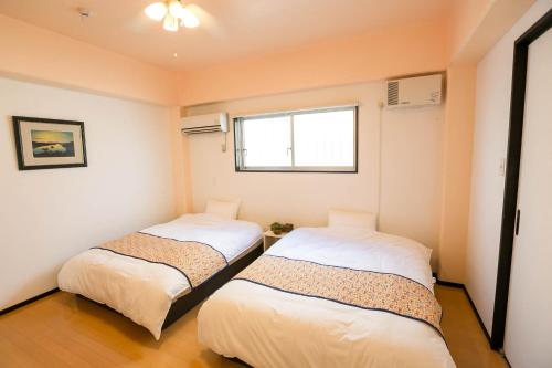 Ένα ή περισσότερα κρεβάτια σε δωμάτιο στο PUBLIC INN OKINAWA
