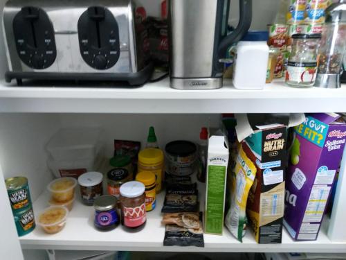 a pantry shelf with food ingredients and a coffee maker at C'est La Vie Bed & Breakfast in Albany