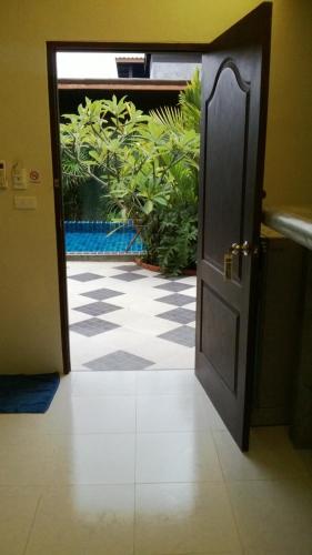 an open door leading to a patio with plants at 2 Home in Chalong 