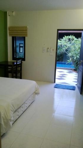 a bedroom with a bed and a door leading to a patio at 2 Home in Chalong 