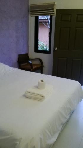 a white bed with a roll of toilet paper on it at 2 Home in Chalong 