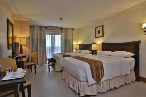 Ένα ή περισσότερα κρεβάτια σε δωμάτιο στο Crown Regency Suites Mactan