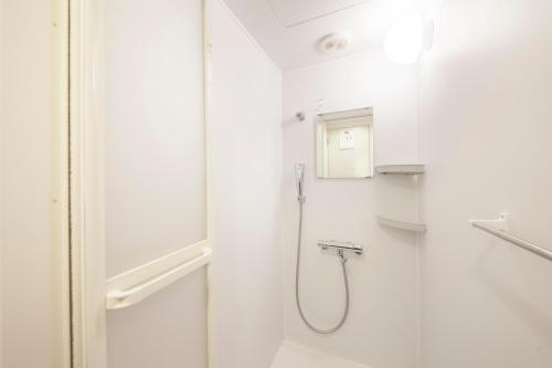 a white bathroom with a shower and a sink at Ueno Station Hostel Oriental 1 Male Only in Tokyo