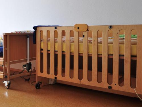 a wooden crib in a room with a table at Bunte Burg in Ebenweiler