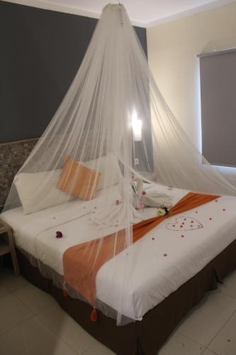 a bedroom with a bed with a mosquito net at Greenotel Cilegon in Cilegon