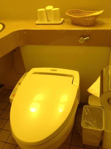 a white toilet in a bathroom with a counter at Hotel Crescent Asahikawa in Asahikawa