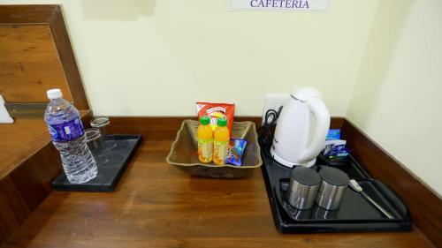 a counter with a coffee maker and a bottle of water at Base9 Cochin Airport Hotel in Nedumbassery