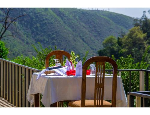 a table with a white table cloth and two chairs at Thomsons Falls Lodge in Nyahururu