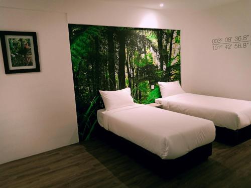 クアラルンプールにあるH Boutique Hotel Xplorer Loke Yewの壁に絵画が飾られた部屋のベッド2台