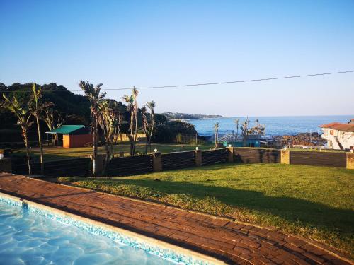 a swimming pool with a view of the ocean at Port Edward Holiday Resort in Port Edward