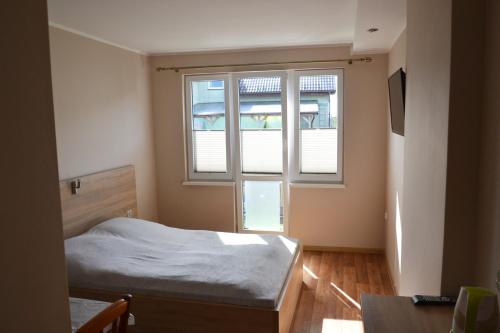 a small bedroom with a bed and a window at Pokoje Gościnne Bartek in Jastrzębia Góra