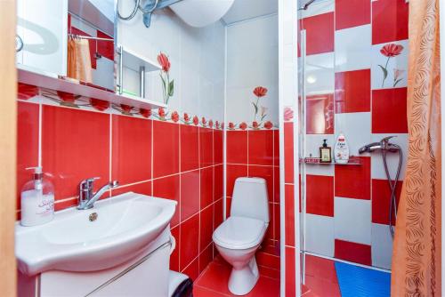 a red and white bathroom with a toilet and a sink at Butai labai geroje vietoje prie juros in Palanga
