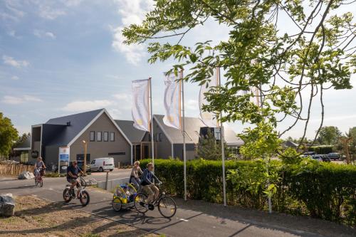 un grupo de personas montando bicicletas por una calle en Zonneweelde, Vakantie aan Zee en Nieuwvliet-Bad