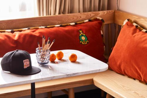 a table with two oranges and a hat on it at Mama Shelter London - Shoreditch in London